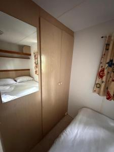 a small bedroom with two beds and a mirror at Sid's mobile home - Camping Riba Roja in Riba-roja d'Ebre