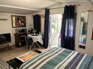 a bedroom with a bed and a table and a window at Chalet des oliviers 10mn CV Béziers dans propriété bien pour cyclistes in Béziers