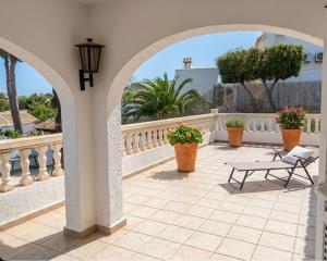 a patio with a bench and flowers on a balcony at Vista Portet, sleeps 10, Private Pool, Sea Views, Squash, 1 km from El Portet beach in Teulada +27 photos