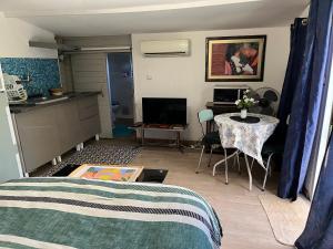 a living room with a kitchen and a table and a room with a bed at Chalet des oliviers 10mn CV Béziers dans propriété bien pour cyclistes in Béziers