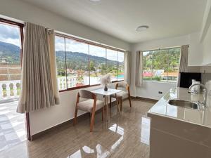 a kitchen with a table and chairs and windows at Mansión Altamirano - Hotel in Talavera