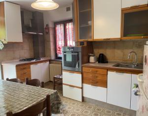 a kitchen with white cabinets and a table and a sink at Martin in Trento
