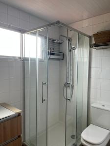 a glass shower in a bathroom with a toilet at Casa Xoubiña in Mos +10 photos
