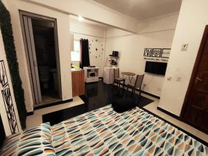a bedroom with a bed and a kitchen with a table at Studio Premium - ap 05 in Diadema