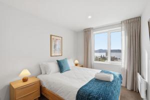 a bedroom with a bed and a large window at Designer Stay with River Views) in Sandy Bay