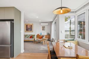 a kitchen and living room with a table and a dining room at Designer Stay with River Views) in Sandy Bay
