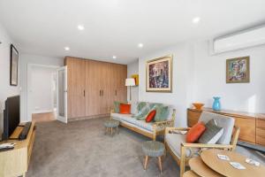 a living room with a couch and a table at Designer Stay with River Views) in Sandy Bay