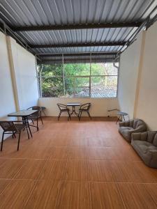 a room with tables and chairs and a large window at Buddy Hostel in Chiang Rai