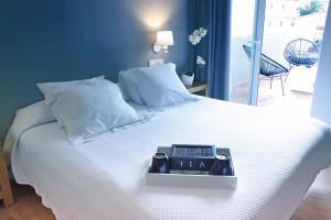 Una cama con un reloj encima. en HOTEL & APARTAMENTS THALASSA Sport & Spa, en Roses