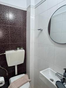 a bathroom with a toilet and a sink and a mirror at Armonia Maisonette in Pefkochori
