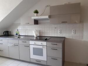 a kitchen with white cabinets and a sink at Gästewohnung in Parkstetten bei Straubing in Parkstetten