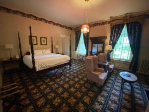 a bedroom with a bed and a couch and a chair at Beaumont Inn in Harrodsburg +228 photos