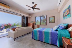 a bedroom with a bed and a couch and a window at 2BR with Stunning Ocean Views in Las Palmas