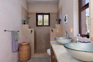 a bathroom with two sinks and a glass bowl at 2BR with Stunning Ocean Views in Las Palmas +46 photos