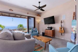 a living room with a couch and a flat screen tv at 2BR with Stunning Ocean Views in Las Palmas