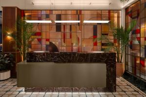 a lobby with a counter with plants and stained glass at Hyatt Union Square New York in New York