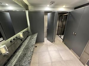 a bathroom with a sink and two stalls in it at MONS hostel in Buenos Aires +100 photos