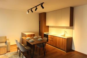 a kitchen and dining room with a table and chairs at NUMA LIVING - Executive Suite in Kumanovo