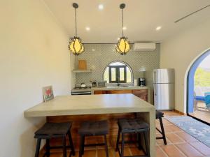 a kitchen with a large kitchen island with stools at Near Beach Casita With Firepit in Los Barriles +21 photos