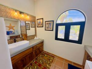 a bathroom with a sink and a mirror and a window at Near Beach Casita With Firepit in Los Barriles