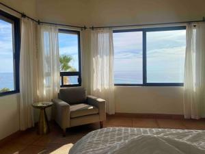 a bedroom with a chair and large windows at Home With Private Pool Ocean and Mountain Views in Los Barriles +58 photos