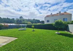 a green yard with a bench and a house at Casa do Telhal in Vila Nova de Gaia