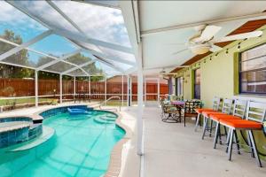 a patio with a swimming pool and tables and chairs at Sunset Oasis (Homosassa Springs) in Homosassa