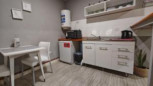a small kitchen with a sink and a table at El Refugio in La Falda