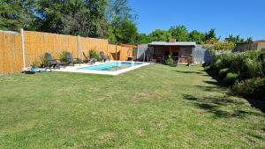 a backyard with a pool with chairs and a fence at El Refugio in La Falda