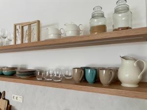 a shelf with cups and glasses on it at Bluewave boho apartment Slnava in Banka