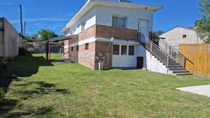 a house with a garage and a grass yard at El Refugio in La Falda