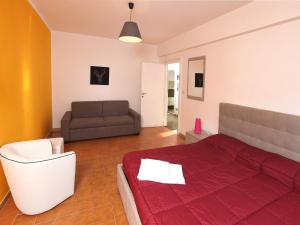 ローマにあるMarina Homeのベッドルーム(赤いベッド1台、ソファ付)