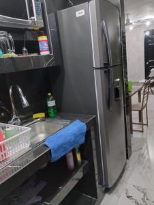 a kitchen with a stainless steel refrigerator and a sink at Casa Rota in Mérida +7 photos