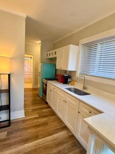 a kitchen with white cabinets and a blue refrigerator at Well Located Studio on the Red Line in Chicago +4 photos