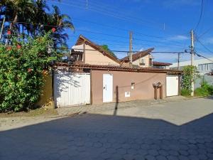 a house with a white gate and a fence at Chale Maresias 1 in São Sebastião