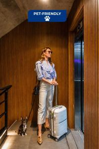 a woman walking a dog with a suitcase at Live Soho Boutique Hotel & Apartments in Buenos Aires