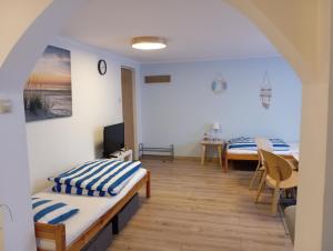 a room with two beds and a table with a television at Chatki Saturnina i pokoje in Świnoujście