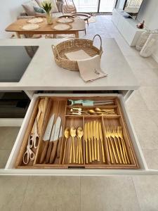 a drawer filled with wooden utensils on a table at Bluewave boho apartment Slnava in Banka