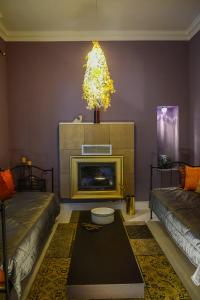 a living room with a fireplace and a chandelier at Maison de la Poupée in Afétai