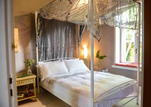a bedroom with a canopy bed and a window at Maison de la Poupée in Afétai