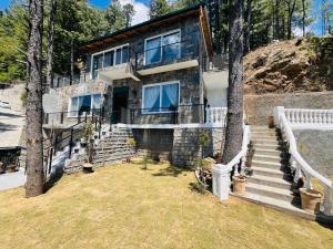 a stone house with stairs leading up to it at Haven Mushkpuri Terraces Khaira Gali - 3BR Home, Lawn, BBQ & Fireplace in Chhāngla Gali