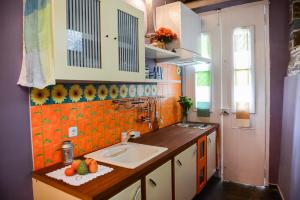 a kitchen with a sink and a counter with oranges at Maison de la Poupée in Afétai +73 photos