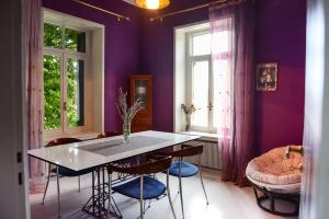 a kitchen with purple walls and a table and chairs at Maison de la Poupée in Afétai