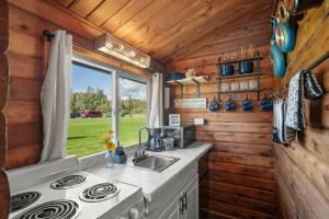 a kitchen in a tiny house with a stove at Mat-Su Resort in Wasilla