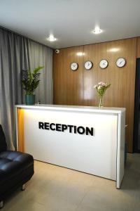 a reception desk in a room with clocks on the wall at Alsun Hotel in Astana