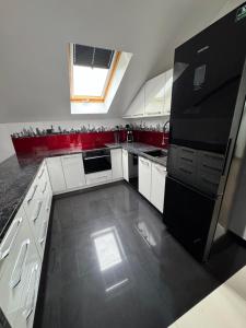 a kitchen with white cabinets and a black refrigerator at Motel Okoń in Orzysz