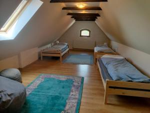 a attic room with three beds and a rug at Fântânele Vacation Home, Charming Rustic Home in Fîntînele