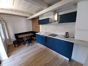 a kitchen with blue cabinets and a table in a room at Fântânele Vacation Home, Charming Rustic Home in Fîntînele