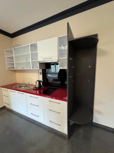 a kitchen with white cabinets and a red counter top at Motel Okoń in Orzysz +19 photos