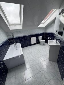 a bathroom with a tub and a sink and a toilet at Motel Okoń in Orzysz